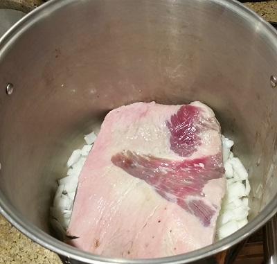 Beef brisket in the pot on top of the onions